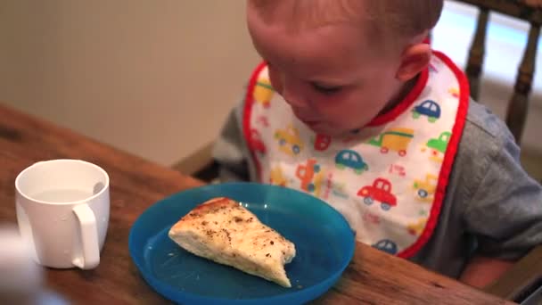 Kleine jongen hete pizza eten — Stockvideo