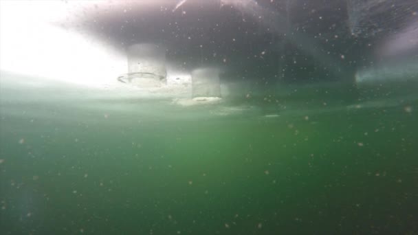 Pescatore mette una macchina fotografica sotto il ghiaccio congelato — Video Stock