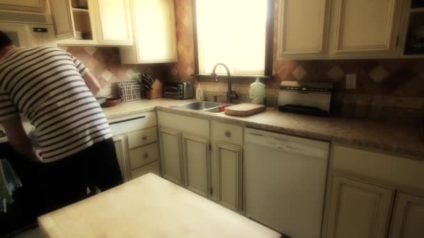 Muž uklízí kuchyň — Stock video