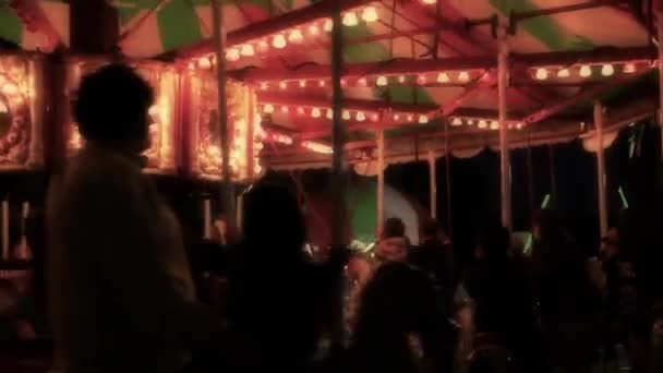 Kids riding carnival carousel — Stock Video