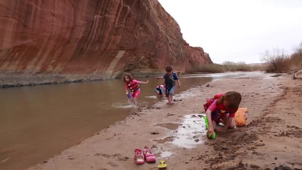 Los niños juegan en la orilla del río — Vídeos de Stock