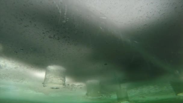 Balıkçı bir kamera altında donmuş buz koyar. — Stok video