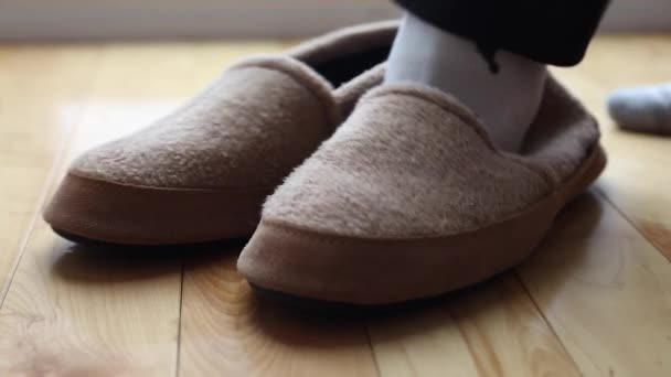 Een man zet comfortabele slippers — Stockvideo