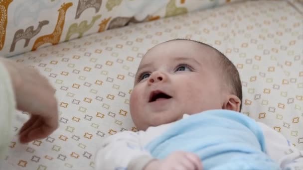 Mamma sätter nyfödda barnet i spjälsängen — Stockvideo