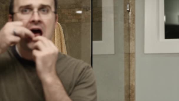 Человек чистит зубы нитью — стоковое видео