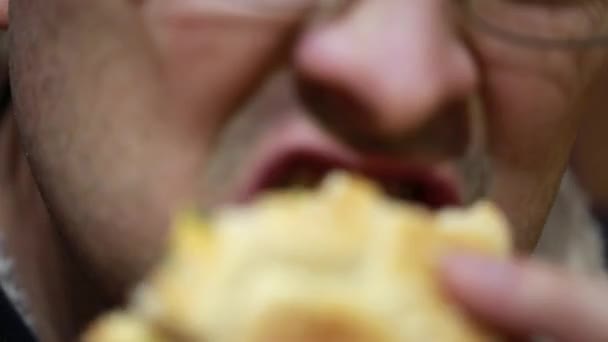 Mężczyzna jedzenie jego hamburger — Wideo stockowe