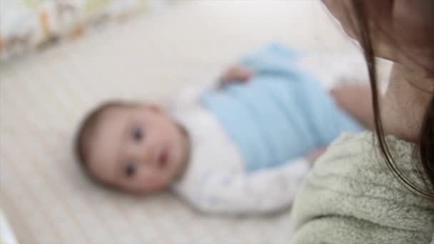 Matka klade novorozené dítě do postýlky — Stock video