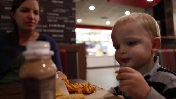 Madre y niño pequeño comiendo comida rápida — Vídeos de Stock