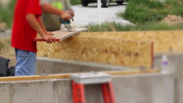 Hombres usando la habilidad de construcción de sierra — Vídeo de stock