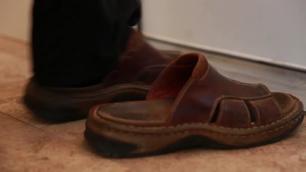 Человек надевает обувь и листья — стоковое видео
