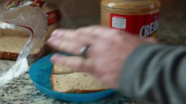 Man bereidt boterham met pindakaas — Stockvideo