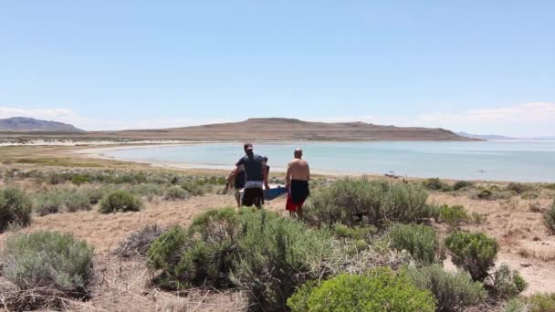 Los hombres llevan el barco a la bahía — Vídeos de Stock