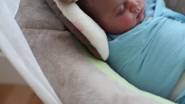 Pasgeboren baby slapen in een schommel — Stockvideo