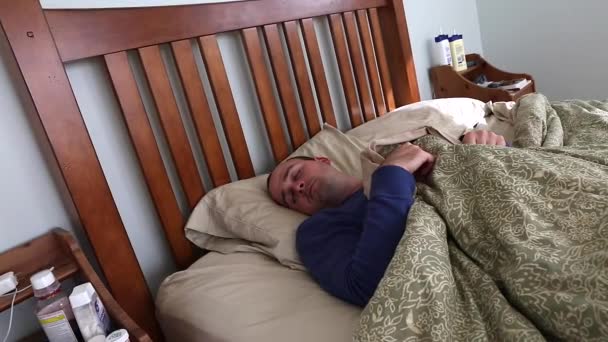 Sick man lying in his bed — Stock Video