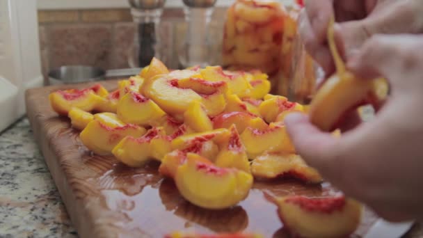 Vrouw pellen en snijden perziken — Stockvideo