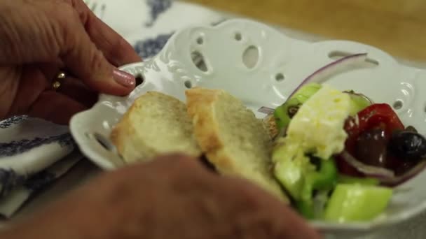 Mujer poniendo ensalada en la mesa — Vídeos de Stock