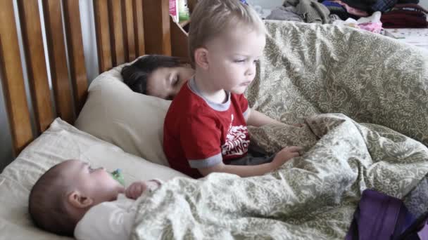 Moeder met een baby- en kindervoeding in haar bed — Stockvideo