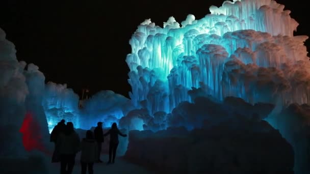 People are walking through ice castle — Stock Video