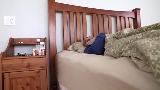 Άρρωστος άντρας ξαπλωμένος στο κρεβάτι του — Αρχείο Βίντεο