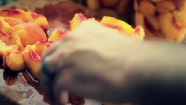 Женщина чистит и режет персики — стоковое видео