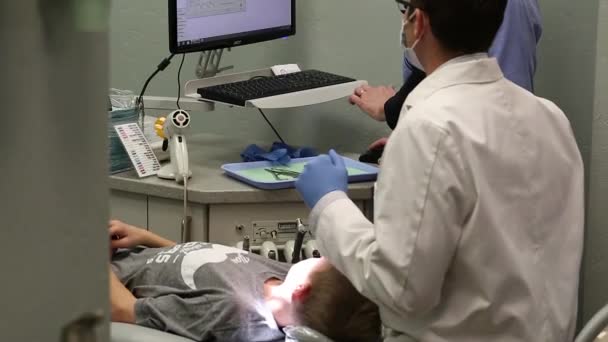 Orthodontist  working on boy's braces — Stock Video