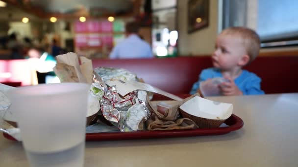 Niño pequeño en un lugar de comida rápida — Vídeo de stock