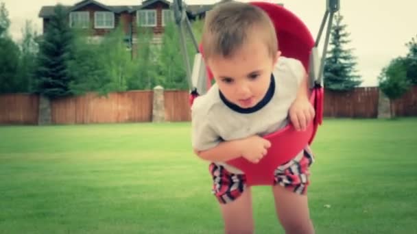 Swingset üzerinde oynarken yürümeye başlayan çocuk — Stok video