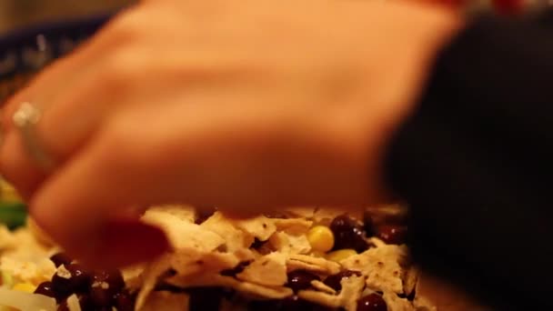 Жінка кладе чіпси на салат — стокове відео