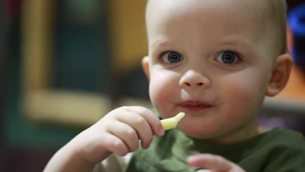 Малыш ест картошку фри — стоковое видео