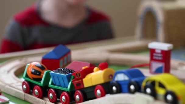 Niño juega con un tren de juguete y coches — Vídeos de Stock