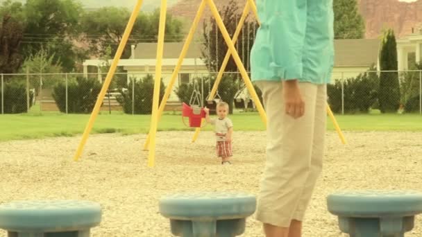 Toddler playing with swings — Stock Video