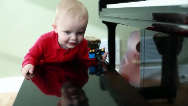Kisgyermek mászik fel, egy zongora — Stock videók