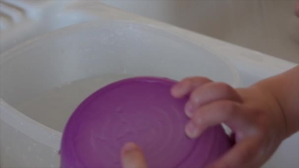 Toddler helps mother clean the dishes — Stock Video