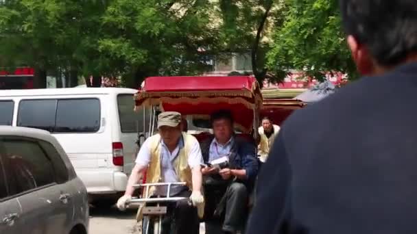 Turister ridning rickshaw genom Beijing — Stockvideo