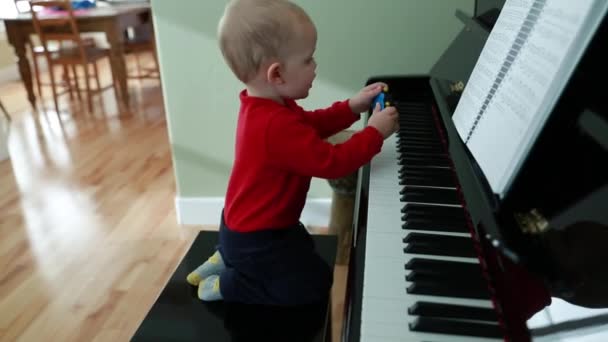 Jongen speelt op een piano — Stockvideo