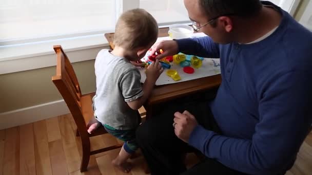 Junge und Vater spielen mit Spielteig — Stockvideo