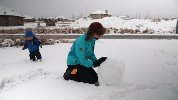 Madre y niño jugando en la nieve — Vídeo de stock