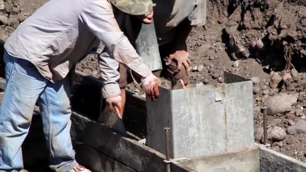 Двоє будівельників заливають підніжки — стокове відео