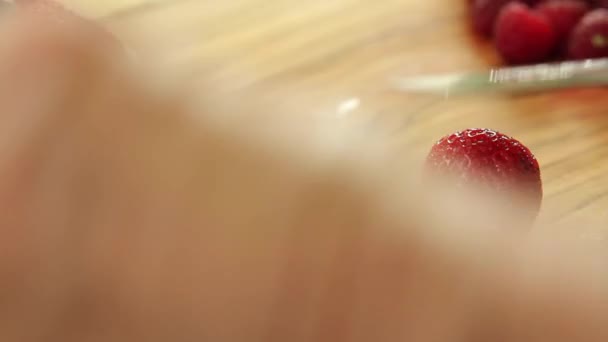 Woman cuts berries and kiwi — Stock video