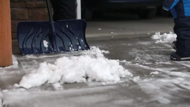 Mujer y niño pequeño paleando nieve — Vídeos de Stock