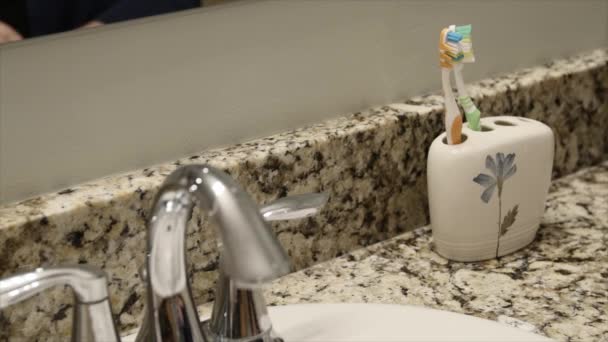 Frau greift zur Zahnbürste — Stockvideo