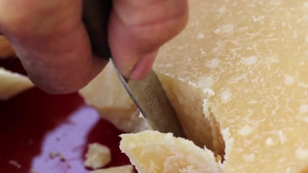 Женщина разбивает сыр пармезан — стоковое видео