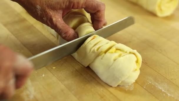 Woman cuts dough for orange rolls — Stock video
