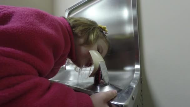 Ребенок пьет в питьевом фонтане — стоковое видео