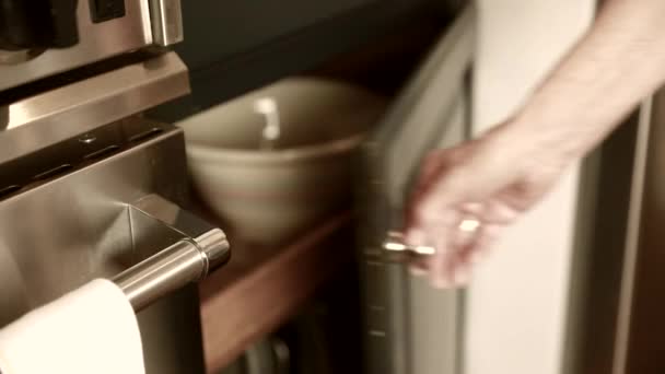 Женщина берет миску из шкафа — стоковое видео