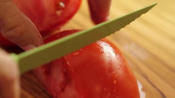 Жінка нарізає червоний стиглий помідор — стокове відео