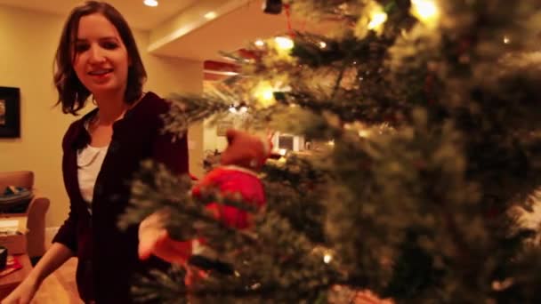 Vrouw versiert kerstboom — Stockvideo
