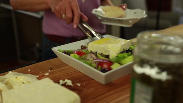 Una mujer prepara una ensalada griega — Vídeos de Stock