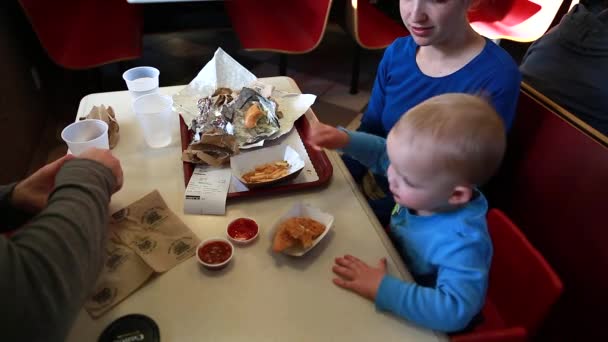 Jeune famille manger Fast-Food — Stockvideo