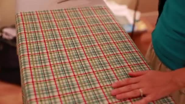 Женщина гладит хлопковую ткань — стоковое видео